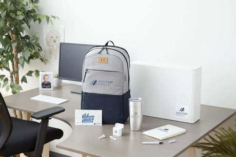 A new hire onboarding kit featuring a branded backpack, stainless steel tumbler, wireless earbuds, notebook, pen, and welcome card.