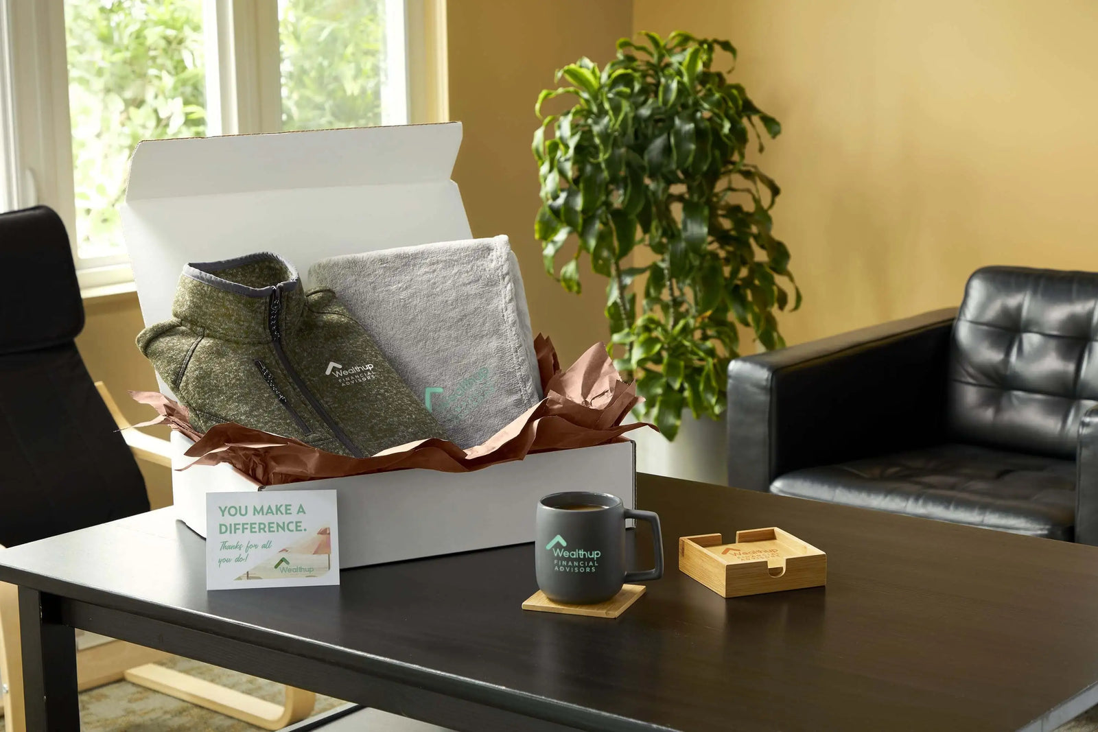 New employee welcome kit featuring a branded fleece, blanket, ceramic mug, coaster, and welcome card.