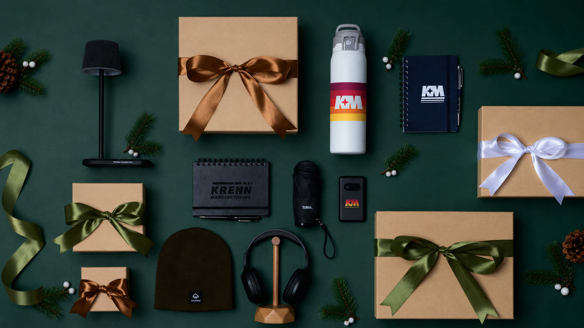 Corporate holiday gift boxes with branded drinkware, notebooks, headphones, and accessories.